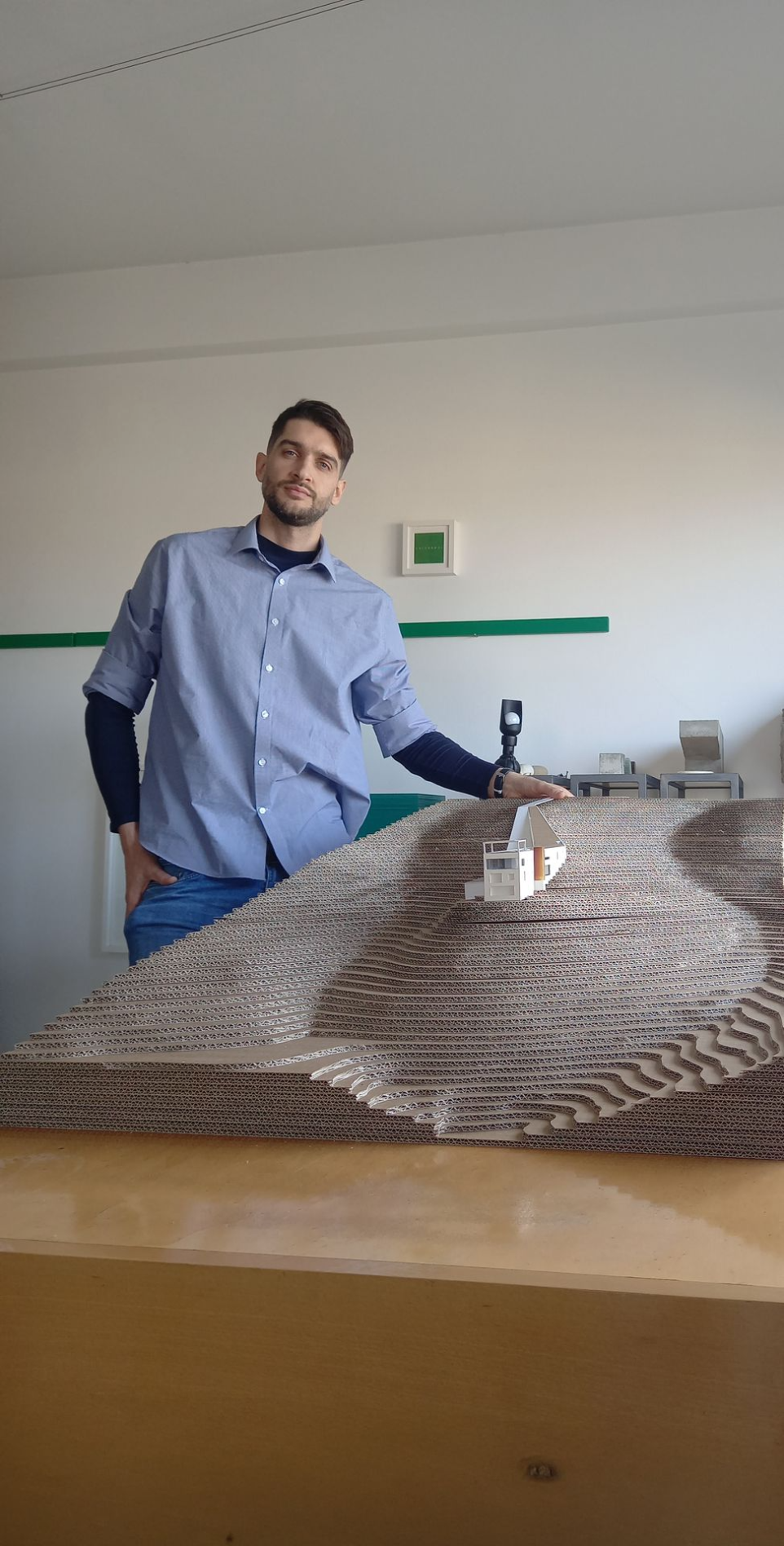 Architect Franco Giardino standing beside an architectural scale model